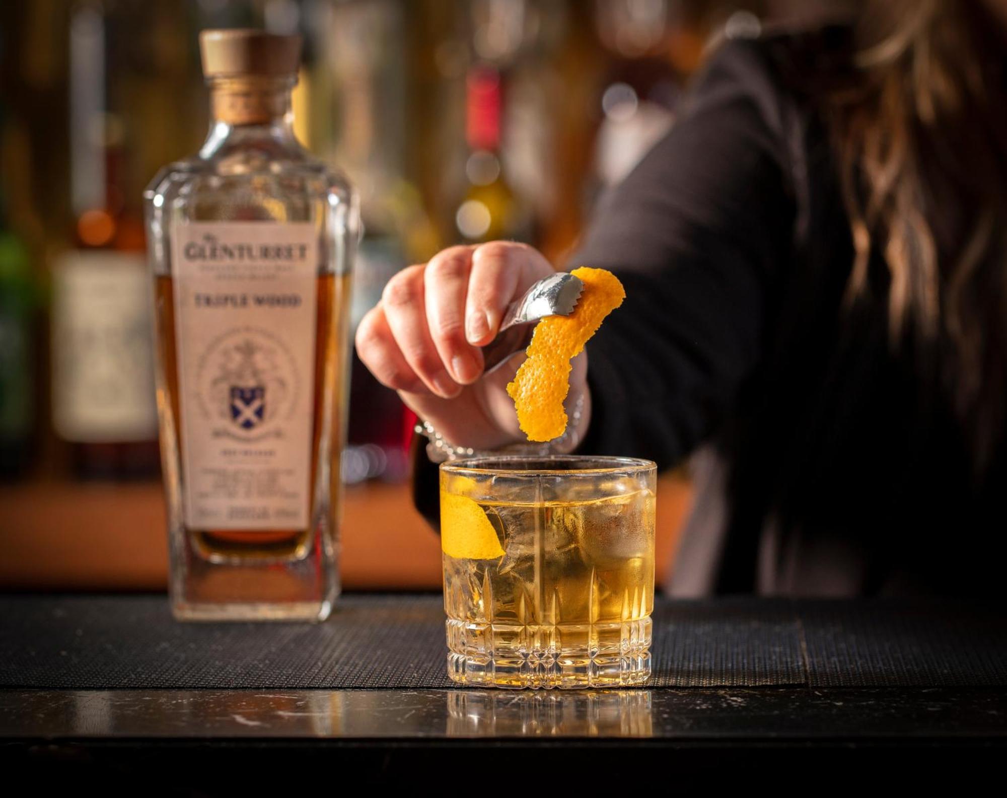 Schloss Roxburghe, Part Of Destination By Hyatt Extérieur photo A bartender adding a lemon twist to a glass of GINfinity